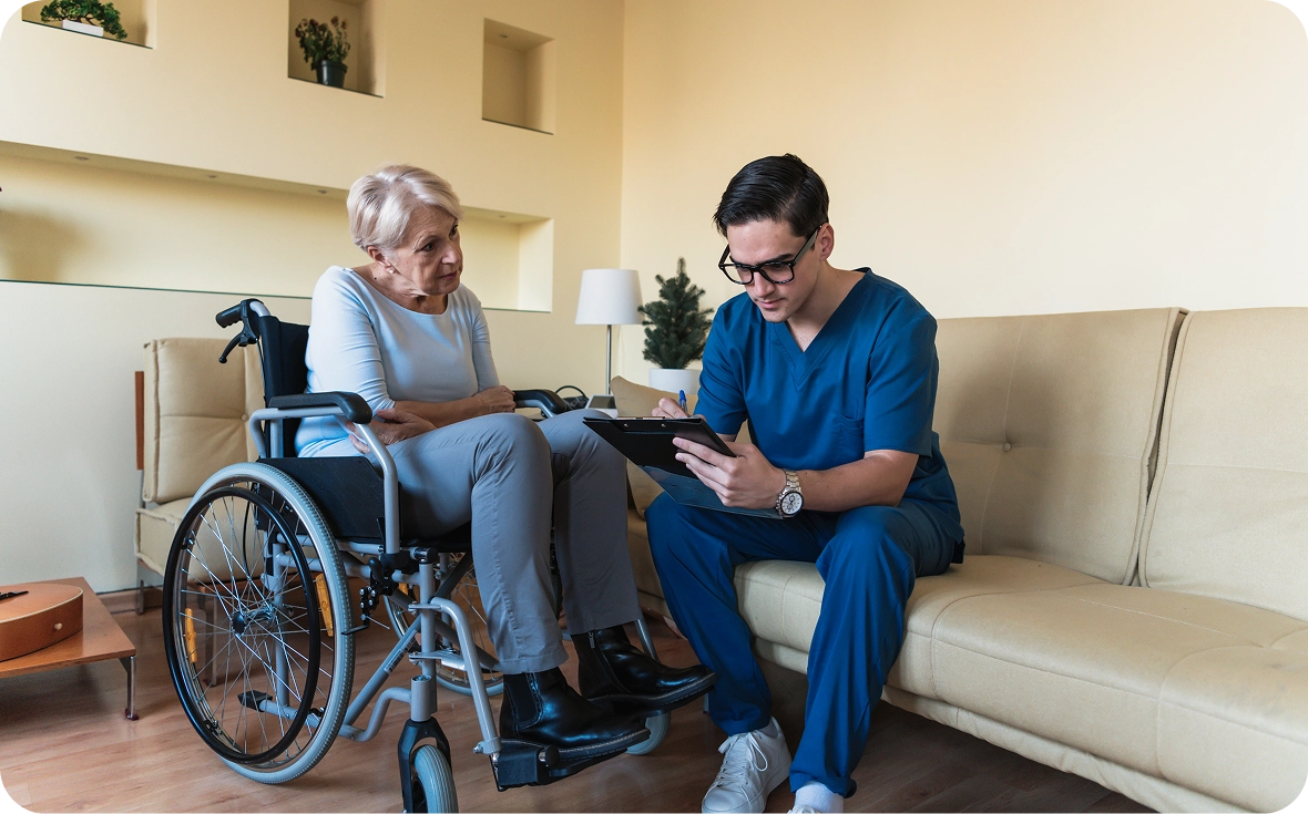 Nurse discussing with wheelchair-bound elderly woman
