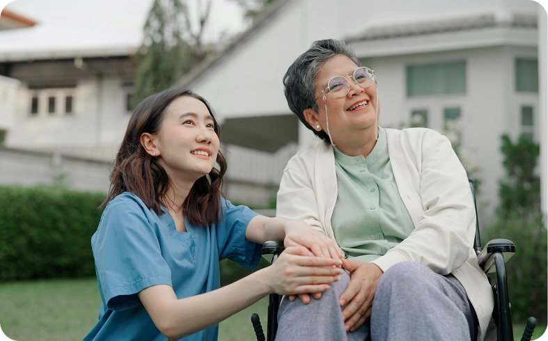 Young nurse comforting senior in wheelchair