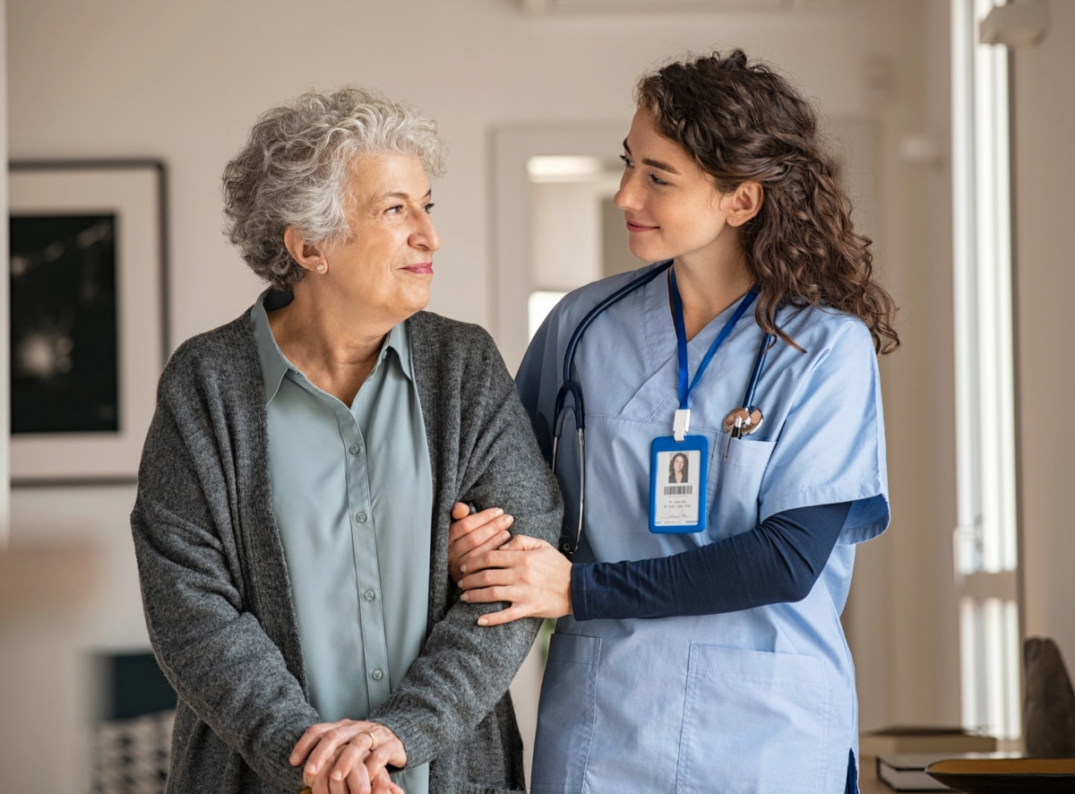 Nurse assisting elderly woman at home