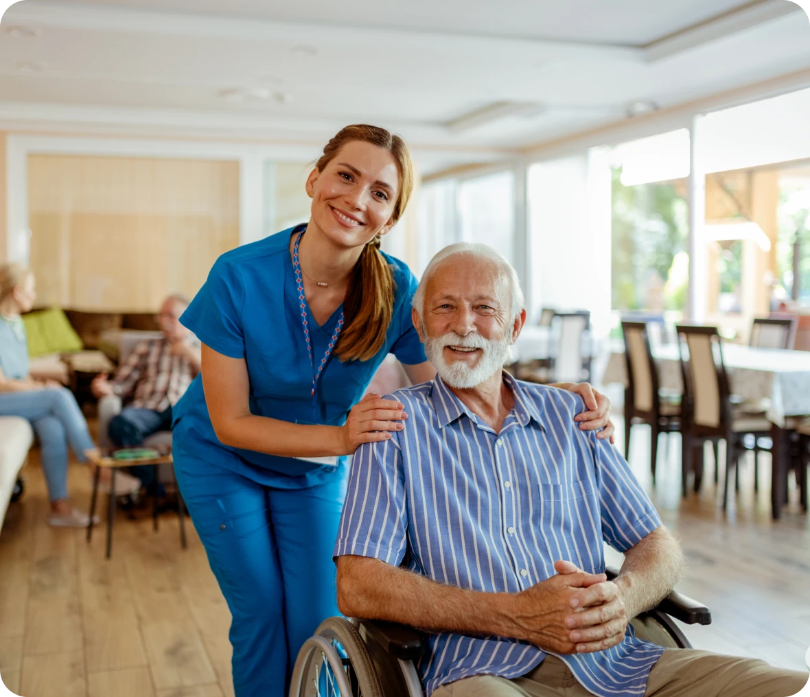 Happy caregiver with senior patient indoors